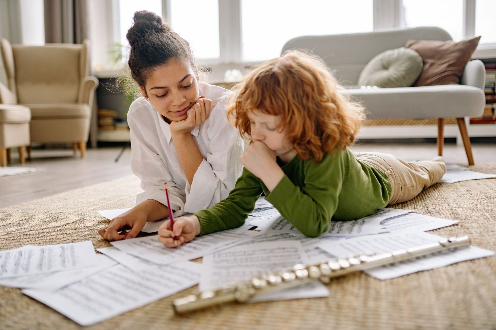 A mother and child study music sheets together at home. Warm and educational setting.